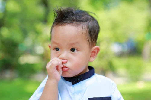 small child holding his nose